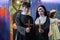 Selective focus on Asian young woman dressed as nun holding the cross in hands and priest at Halloween party