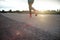 Selective focus on the asphalt road with motion blurred athlete jogging in background