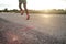 Selective focus on the asphalt road with motion blurred athlete jogging in background