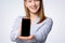 Selective focus of beautiful blonde woman, consultant , and showing smartphone a where you can enter your information. Marketing