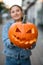 selective focus on beautiful bright orange pumpkin with carved smiling face in female hands