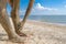 Selective focus on beautiful female foot with bright red pedicure on the beach sand. Hands smear healing mud on the