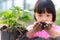 Selective focus on the black land in the kid girl`s hand She was putting the soil in a bag to plant the tree saplings. to grow