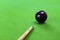 Selective focus on black snooker ball and cue in foreground