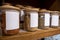 Selective focus on blank labeled seasoning jars inside a cupboard in a home kitchen