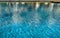 Selective focus on the blue surface of the water in the pool with reflections. Relaxing natural background