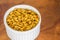 Selective focus of a bowl of pumpkin seeds on a wooden surface