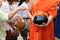Selective focus on bowl. Thai people put food to a Buddhist monk`s alms bowl in Songkran festival Day