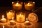 Selective focus of burning candles in glass glowing in dark near rolled towel on marble surface