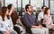 Selective focus on caucasian beard working man wearing eyeglasses, business shirt, doing workshop in indoor seminar room and