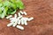 Selective focus at center of the picture.  With blurred herb capsule with herbal leaf on natural wooden background with copy space