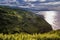 Selective focus on cliff vegetation, mountains with dramatic sky and lowlight along the Atlantic Ocean in Porto Formoso,SÃ£o Migue