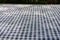 Selective focus and close up shot of white-blue checker pattern fabric on table shows beautiful detail woven textile. It is retro