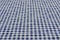 Selective focus and close up shot of white-blue checker pattern fabric on table shows beautiful detail woven textile. It is retro