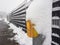 Selective focus. A close-up of a snow-covered yellow German pedestrian crossing button