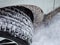 Selective focus. Close-up of a winter car tire tread with snow and ice