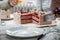 Selective focus closeup of a hand holding a knife slicing the cake on the