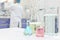 Selective focus of colored laboratory chemicals with blurred male scientist working on the background.