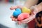 Selective focus colorful multicolor knitting hearts held by female`s both hands, representing helping hands, supports, assistance,