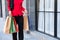 Selective focus at colorful shopping bags. Women carry many shopping back and walking out from fashion department store. End of