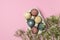 Selective focus of coloured decorated easter eggs in cardboard container, gypsophila flowers