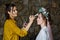 Selective focus. Creative work. A young female stylist makes up a beautiful bride with a hairstyle and a flower wreath. Morning of