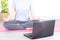 Selective focus crop of woman sitting on floor doing yoga tutorial with laptop at home on self