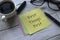 Selective focus of a cup of coffee, pen, glasses and memo notes written with First Things First on white wooden background