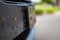 Selective focus on dead bugs splattered to the front grill and plates of a vehicle