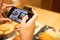 Selective focus at device screen. Women hand using smartphone to take photo of Japanese food for send or share with her friend or