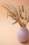 Selective focus. ears of wheat stand in a vase on a pink background. monochrome, minimalism