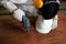 Selective focus on electric drill work on wooden board with hands of young carpenter in carpentry workshop.