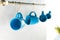 selective focus of empty blue cups hanging in kitchen