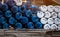 Selective focus on empty old chemical barrels. Blue and white oil drum. Plastic oil tank. Toxic waste warehouse. Hazard chemical