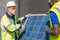 Selective focus at engineer face. African and Caucasian engineer inspect electrical solar panel at building construction site.