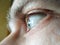 Selective focus eye of caucasian man. Macroshot texture of male skin surface, wrinkles, retina, eyelashes, eyebrows. Ð¡oncept of
