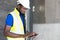 Selective focus at face of Black African foreman at building construction site, wearing protective hat and safety equipment while