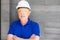 Selective focus at face of Caucasian foreman at building construction site, wearing protective hat and safety equipment while