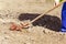 Selective focus of female gardener using red manual cultivator to loosening, tillage, in spring