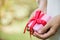 Selective focus female hand holding a gift box with red ribbon.