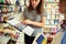 Selective focus. Female seller holding a metal case with watercolor paints in removable refills. School stationery store