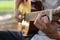 Selective focus of finger of guitarist playing acoustic guitar on blurred nature background.