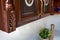 Selective focus fragment of cherry alder wooden cabinetry kitchen carved detail. Carved decorative detail. Wooden