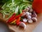 Selective focus of fresh chilies and garlics on a wooden cutting board prepared for cooking