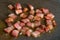 Selective focus. Fried crispy bacon/pancetta, sliced â€‹â€‹in small squares, fried in a gray pan