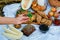 Selective focus. The girl takes a sandwich. Summer picnic with bruschettas with salmon, berries, melon on a wooden board and a