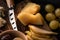 Selective focus of grana padano with pieces of pear, bowl of olives, knife, dorblu, grapes on cutting board.