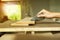 Selective focus on a hand of carpenter holds the sand paper and scrubs on the wood surface at the factory