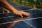 Selective focus on a hand checking a solar panels surface, promoting renewable energy