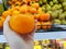 Selective focus of hand holding ripe persimmons on blurred kiwi and  persimmons